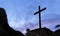 Conceptual religious christian cross standing on rock on the mountain