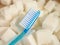 conceptual still life image of toothbrush over massive pile of sugar cubes in dental care and oral hygiene concept as war