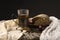 Conceptual still life of pieces of bread, onion bulb, a glass of