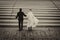 Conceptual symbolic photography. At the crosswalk, the bride in white, the groom in black. Metaphor of the beginning, the