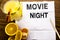 Conceptual text caption showing Movie Night. Concept for Wathing Movies written on tissue paper on the wooden background with pen