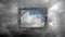 Conceptual time laps video of a blue sky with fast moving cumulus clouds in a vintage frame against a rainy sky with gray clouds.