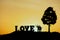 Conceptual valentine holiday illustration. Happy couple holding each other enjoying sunset view under a big tree with love word