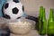 Conceptual watching football game at sofa on television with beer bottles and popcorn bowl in friends enjoying soccer game TV