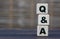 Conceptual word Q $ A on cubes on a gray blurred background