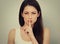 Concerned casual woman with long hair showing silence sign holding finger near the lips and want to say - Attention.. Closeup