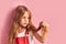 Concerned little girl looking at hair  over pink background