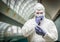 Concerned Man Wearing HAZMAT Protective Suit Holding Blood Test Tube