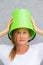 Concerned woman with bucket on head