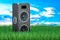 Concert loudspeaker in green grass against blue sky, 3d rendering