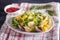 Conchiglie colored pasta with fresh greengrocery on a linen tablecloth on black wooden background