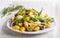 Conchiglie colored pasta with fresh greengrocery on a linen tablecloth on white wooden background