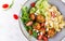 Conchiglie with meatballs, feta cheese and salad on light background.