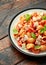 Conchiglie Tuna pasta with tomato sauce, feta cheese and basil on wooden table.