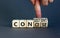 Concise or consistent symbol. Businessman turns wooden cubes and changes concept word Concise to Consistent. Beautiful grey table