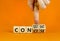 Concise or consistent symbol. Businessman turns wooden cubes and changes concept word Concise to Consistent. Beautiful orange