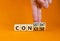 Concise or consistent symbol. Businessman turns wooden cubes and changes concept word Concise to Consistent. Beautiful orange