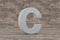 Concrete 3d letter C uppercase. Hard stone letter on wooden background. 3d rendered font character.