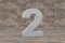 Concrete 3d number 2. Hard stone number on wooden background. 3d rendered font character.