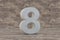 Concrete 3d number 8. Hard stone number on wooden background. 3d rendered font character.