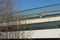 Concrete beam of car bridge, bare branches and green railings against blue sky
