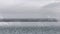 Concrete block pier above the surface of the overcast sea or ocean. Empty bridge, concrete slab or platform on calm foggy water.