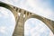 Concrete bridge over a cloudy background with several eyes in its structure to reinforce each large arch