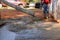 Concrete construction contractors working on a pouring wet concrete while paving a driveway