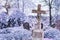 Concrete cross with crucifix in cemetery in winter