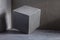 Concrete cube near wall background texture. Art or construction concept of minimalism design