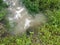 Concrete cylindrical canal drainage flows stagnant by the overgrowth plant and weed.