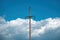 Concrete electricity pole with wires against cloudy sky