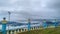 Concrete fence, electric wires, foggy and hill under thick clouds.