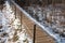 Concrete footpath with metal railings, snow, dry grass