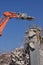 Concrete industrial building demolition - building destruction with machinery - blue sky - stock