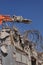 Concrete industrial building demolition - building destruction with machinery - blue sky - stock