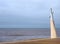 Concrete lamp on the promenade along the seafront at cleveleys in blackpool with steps leading to the beach with breaking waves on