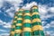 Concrete mixing plant. Four vertical towers for storing cement, the towers are painted in yellow and green stripes.