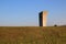 The concrete monument on the background of green grass and sky