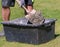 Concrete mortar mixed in black bucket with spade by worker in garden, close up