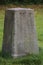 Concrete obelisk standing on a green lawn