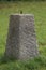 Concrete obelisk standing on a green lawn