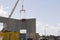 Concrete panels being lifted to build a warehouse.