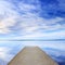 Concrete pier or jetty and on a blue lake and sky reflection on water.