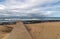 Concrete Pipeline Extending onto Beach and Rocky Coastal Seasc