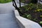 Concrete retaining wall at the large staircase in the park the flowerbed area is planted with rich greenery of perennials granite