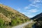 concrete road along green hills in New Zealand for trip