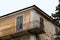 Concrete with rusted metal fence edge balcony on side of old dilapidated abandoned building with cracked facade