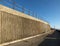 Concrete seawall and railings along the pedestrian promenade in north blackpool with the tower and town in the distance in