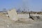 Concrete slab stuck in the ground against the background of a Smoking electrical substation. Background